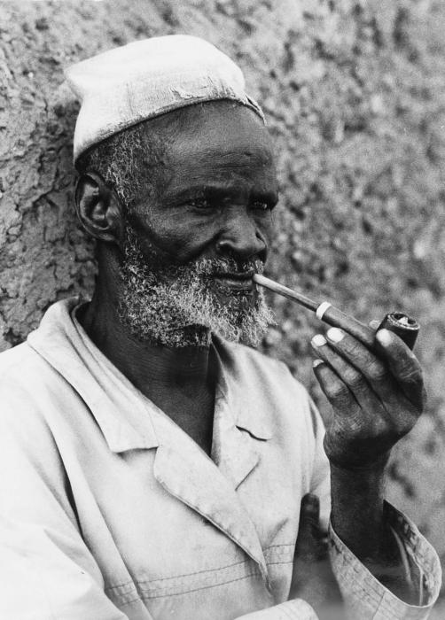 COLLECTIE TROPENMUSEUM Portret van een oudere Samo man die een pijp rookt TMnr 20010112